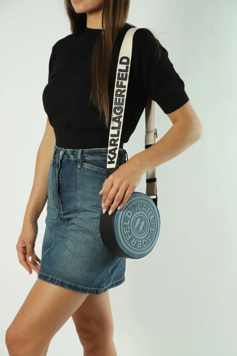 Bolso bandolera azul circular con logo monocromático