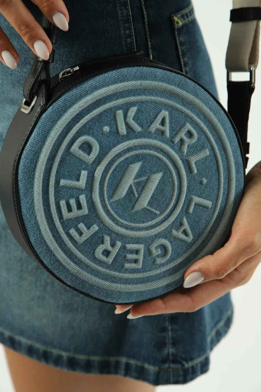 Bolso bandolera azul circular con logo monocromático